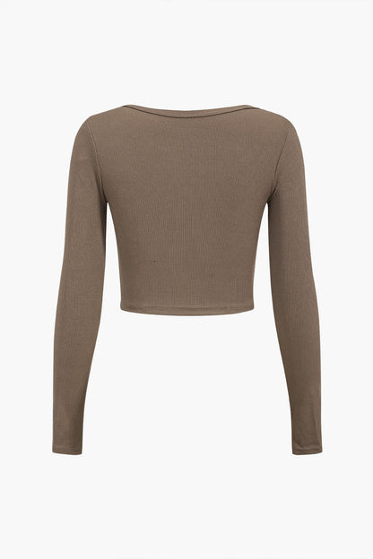 Top asymétrique manches longues avec décolleté et boutons déco